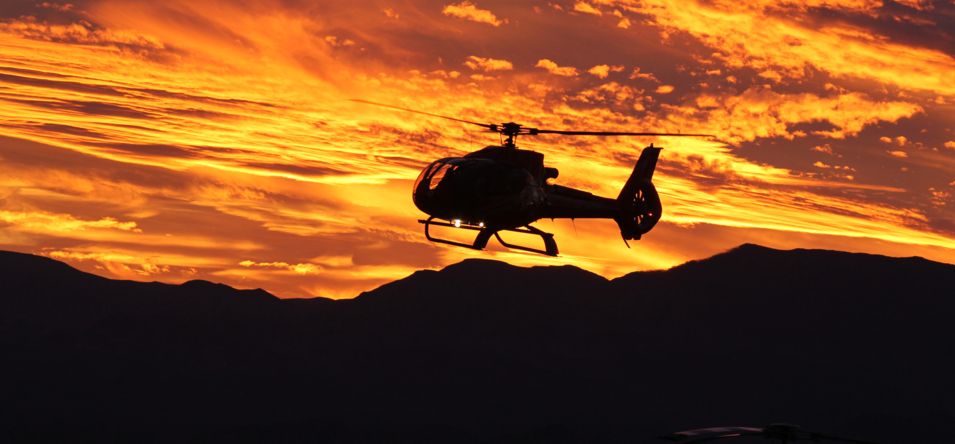 A Las Vegas helicopter tour flies over a golden sunset